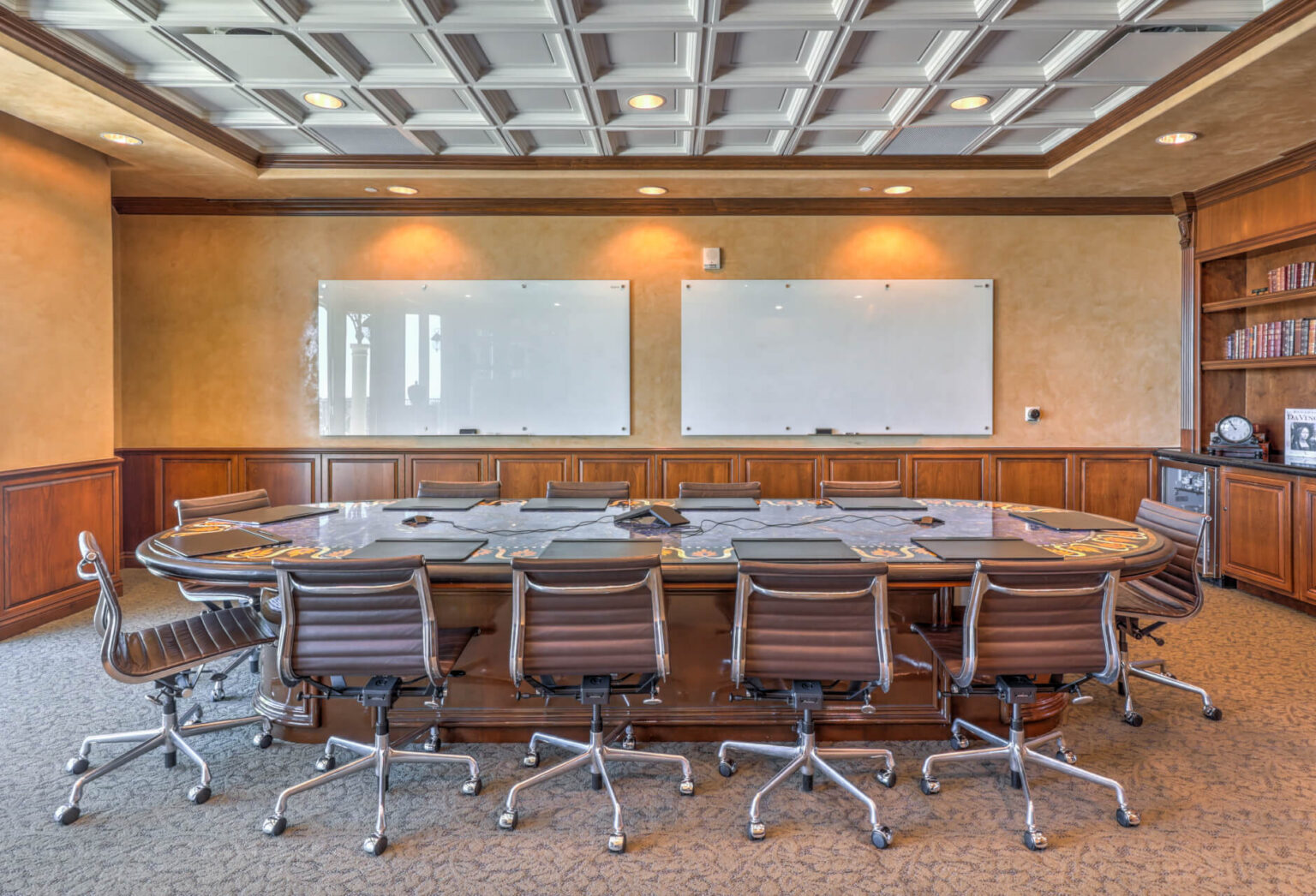 A sophisticated conference room featuring an elegant large table surrounded by plush chairs, ideal for business meetings.