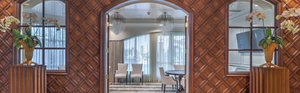 A luxurious hallway featuring a polished wooden wall and an elegant mirror reflecting the sophisticated ambiance.