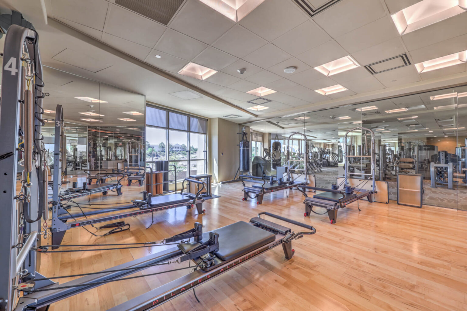 A spacious gym featuring various exercise equipment arranged throughout a large, open room.